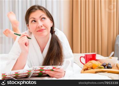 young woman with a notebook and breakfast in bed