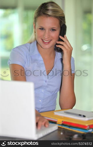 Young woman with a phone and laptop