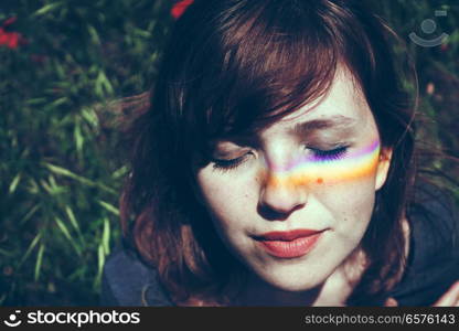 Young woman with a rainbow in her face