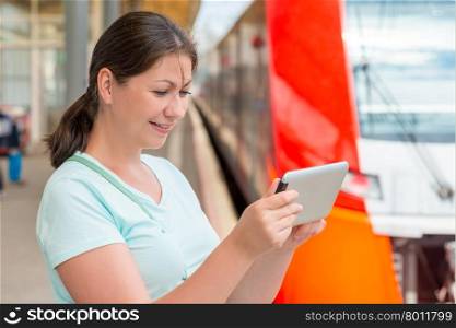young woman with a tablet at the station