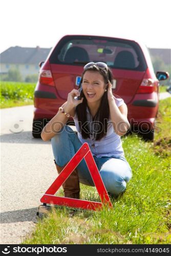 young woman with a warning triangle in case of breakdown