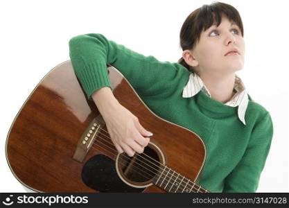 Young woman with acoustic guitar. Green sweater, black hair, blue eyes. Shot in studio over white.