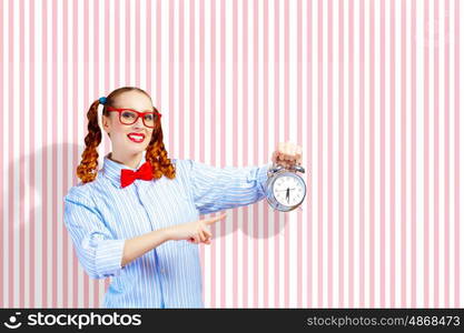 Young woman with an old-fashioned alarm clock