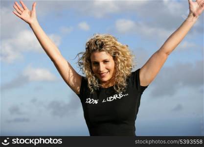 Young woman with arms up outdoors