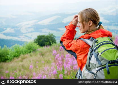 Young woman with backpack hiking in the mountains