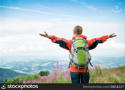 Young woman with backpack hiking in the mountains
