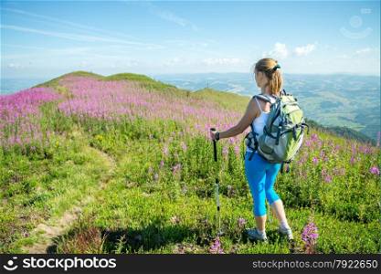 Young woman with backpack hiking in the mountains