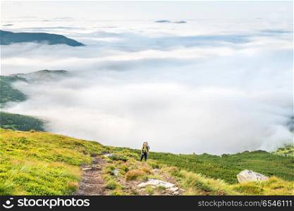 Young woman with backpack travels in mountains . Young woman with backpack in mountains