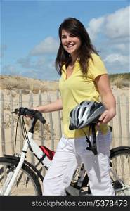Young woman with bike at the beach