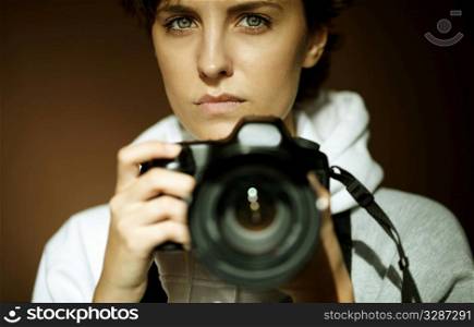 young woman with black slr camera, natural light, selective focus on eye