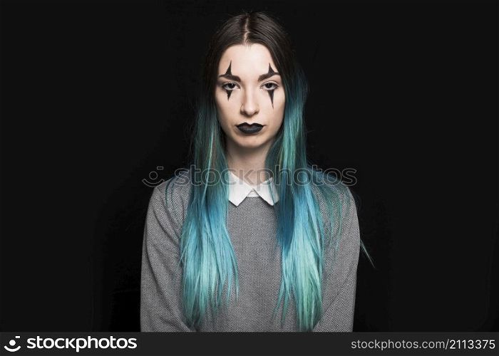 young woman with blue hair makeup standing studio