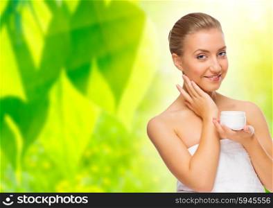 Young woman with body cream on floral background