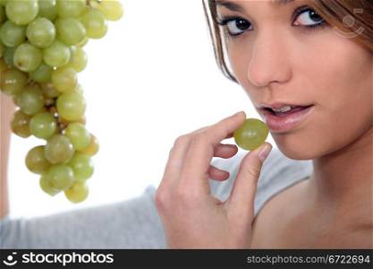 Young woman with bunch of grapes