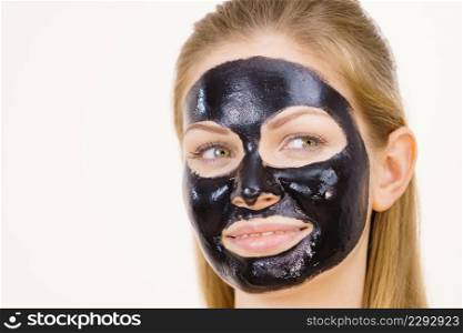 Young woman with carbo detox black peel-off mask on her face, on white. Teen girl taking care of oily skin, cleaning the pores. Beauty treatment. Skincare.. Girl black carbo peel off mask on face