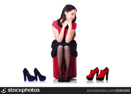 Young woman with choice of shoes on white