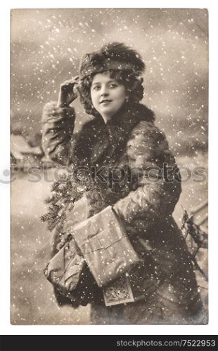 Young woman with christmas tree and gifts. Vintage picture with original film grain and blur