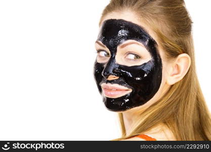 Young woman with cosmetic on face, carbo detox black peel off mask. Spa treatment. Skincare.. Woman with black peel off mask on face