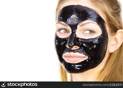Young woman with cosmetic on face, carbo detox black peel off mask. Spa treatment. Skincare.. Woman with black peel off mask on face