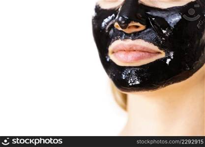 Young woman with cosmetic on face, carbo detox black peel off mask. Spa treatment. Skincare. Lips detail.. Woman with black peel off mask on face