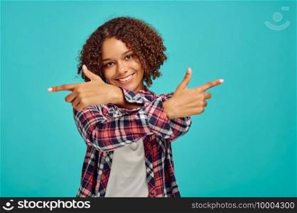 Young woman with crossed hands, blue background, positive emotion. Face expression, female person looking on camera in studio, emotional concept, feelings. Young woman with crossed hands, blue background