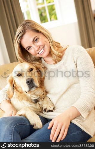 Young woman with dog sitting on sofa