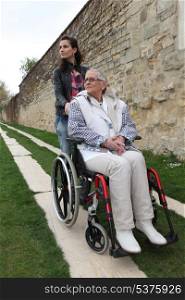 Young woman with elderly woman in wheelchair