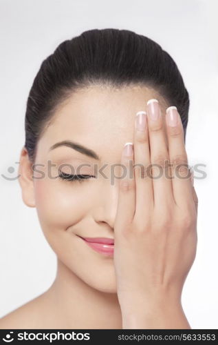 Young woman with eyes closed covering her half face