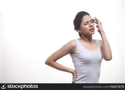 Young woman with eyes closed suffering from headache isolated over white background
