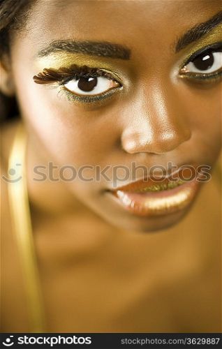 Young Woman with False Eyelashes and Gold Lipstick