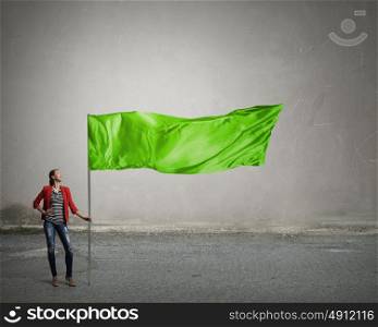 Young woman with flag. Young woman in red jacket holding waving flag