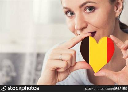 Young woman with gingerbread heart cookies with flag of Belgium. Young woman with gingerbread heart cookies with flag. Young woman with gingerbread heart cookies with flag