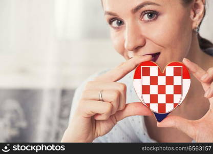 Young woman with gingerbread heart cookies with flag of Croatia. Young woman with gingerbread heart cookies with flag. Young woman with gingerbread heart cookies with flag