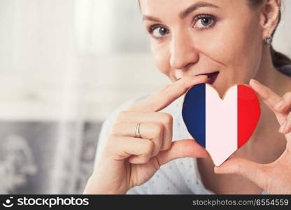 Young woman with gingerbread heart cookies with flag of France. Young woman with gingerbread heart cookies with flag. Young woman with gingerbread heart cookies with flag