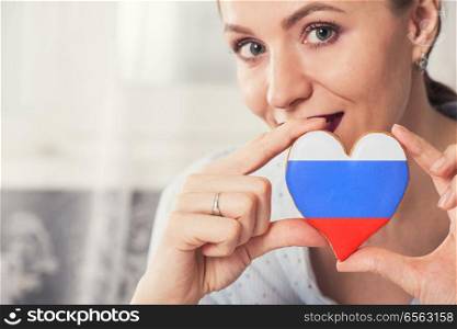 Young woman with gingerbread heart cookies with flag of Russia. Young woman with gingerbread heart cookies with flag. Young woman with gingerbread heart cookies with flag