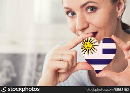 Young woman with gingerbread heart cookies with flag of Uruguay. Young woman with gingerbread heart cookies with flag. Young woman with gingerbread heart cookies with flag