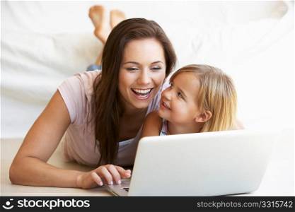 Young woman with girl using laptop computer