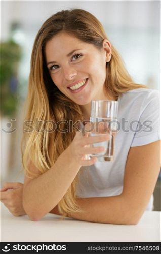young woman with glass of water indoors