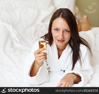 young woman with glasses of champagne wearing bathrobe