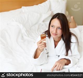 young woman with glasses of champagne wearing bathrobe