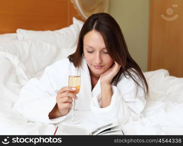 young woman with glasses of champagne wearing bathrobe