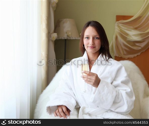 young woman with glasses of champagne wearing bathrobe