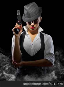 Young woman with gun on black