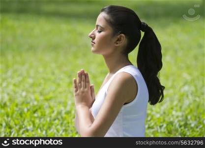 Young woman with hands in prayer position