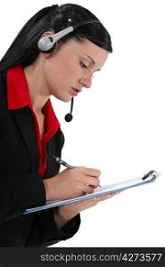 Young woman with headset and notepad