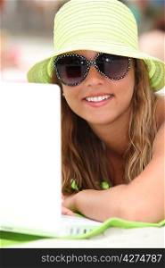 Young woman with her laptop at the beach