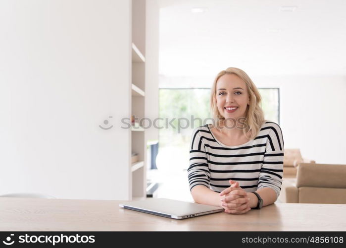 Young woman with her laptop computer in her luxury modern home, smiling