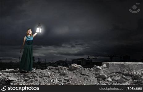 Young woman with lantern walking in darkness. Lost in darkness