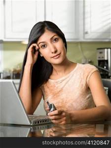 Young Woman With Laptop and Holding Cellphone