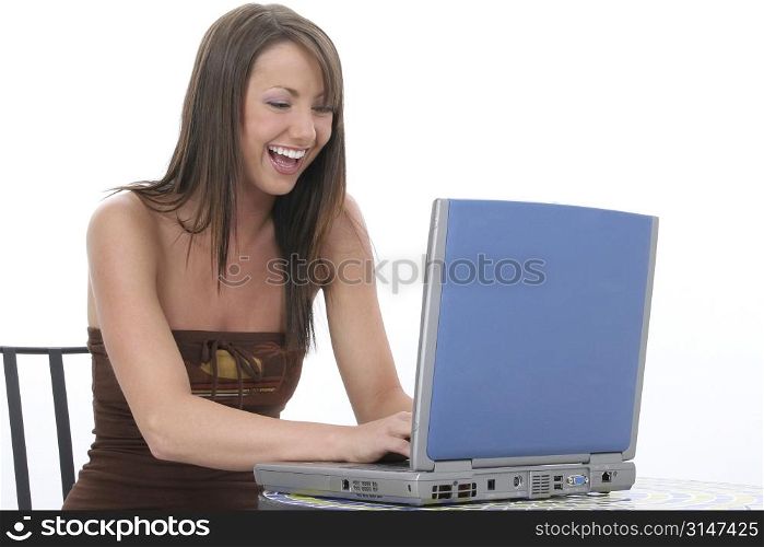 Young woman with laptop computer sitting at bistro table.