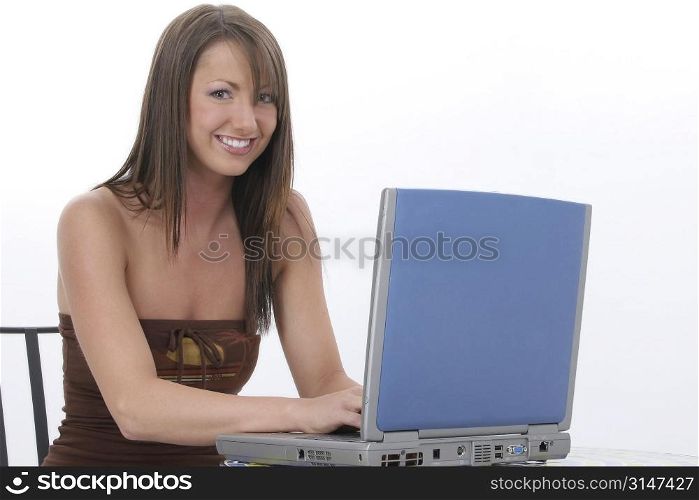 Young woman with laptop computer sitting at bistro table.